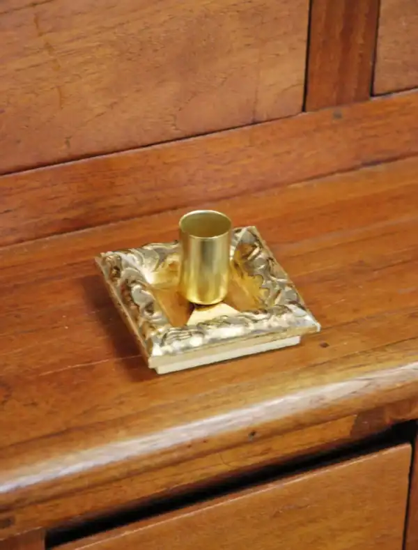 A golden candlestick on a wooden table, an accent of luxury and elegance.